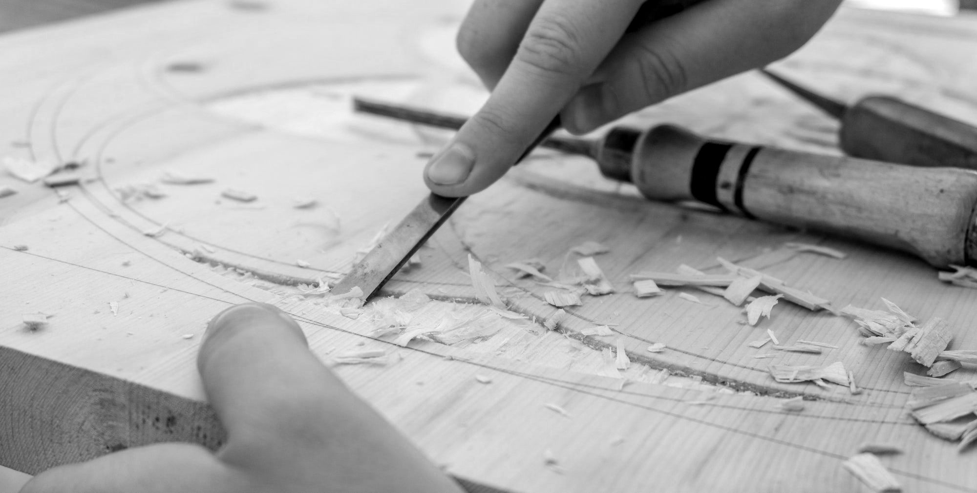 person using chisel while curving wood
