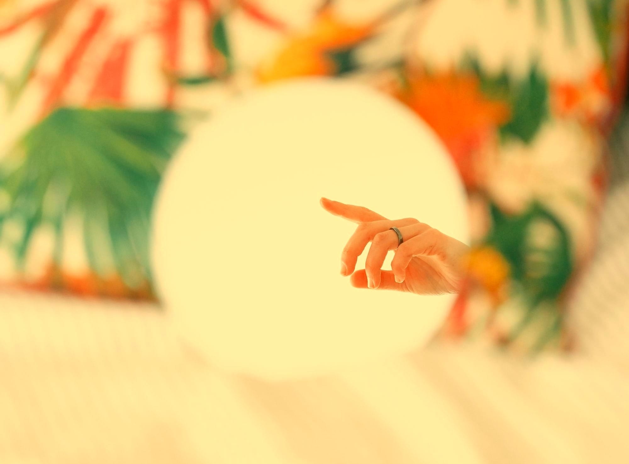 a person pointing at a white object on a bed